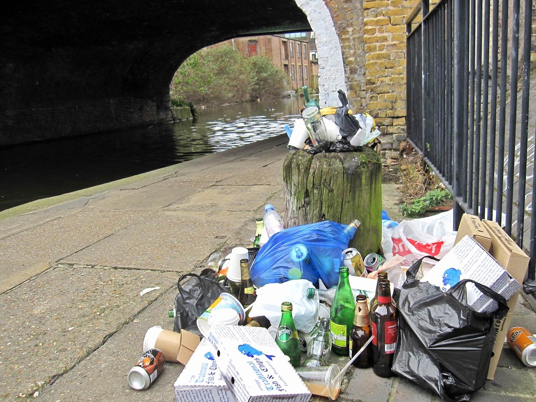 rubbish dumped in and around overflowing bin on Regents Canal in Haggerston