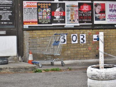 Abandoned supermarket shopping trolley on brownfield site in London