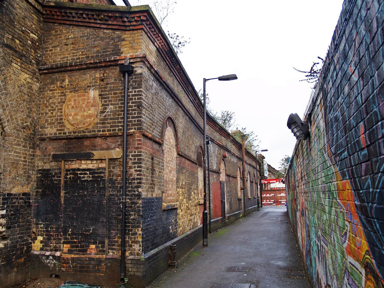 Alleyway and bricked up entrance to Southwark Park ghost railway station in Bermondsey, South London