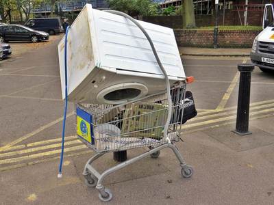 supermarket shopping trolley containing a dumped washing machine in  London