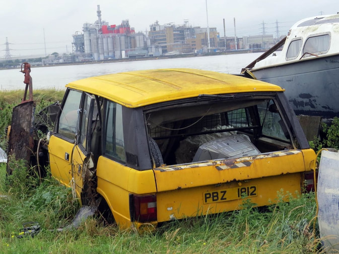 Picture of abandoned yellow Range Rover on Swanscombe Marshes at the peninsular on mainly derelcit brownfield land with the odd decaying boat and motor vehicle