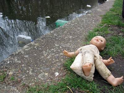unwanted child's doll flytipped beside Regent's Canal in Hackney