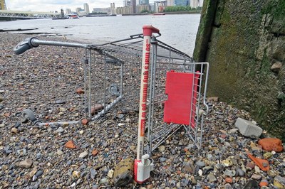 discarded Iceland supermarket shopping trolley on the Thames foreshore at low tide