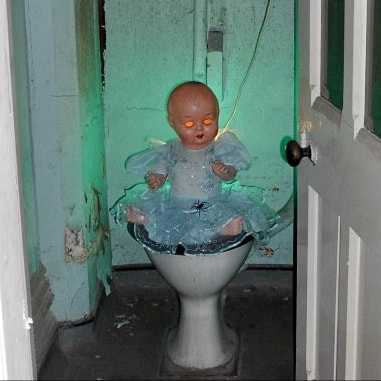 Doll sitting on the toilet in abandoned St Pancras Hotel