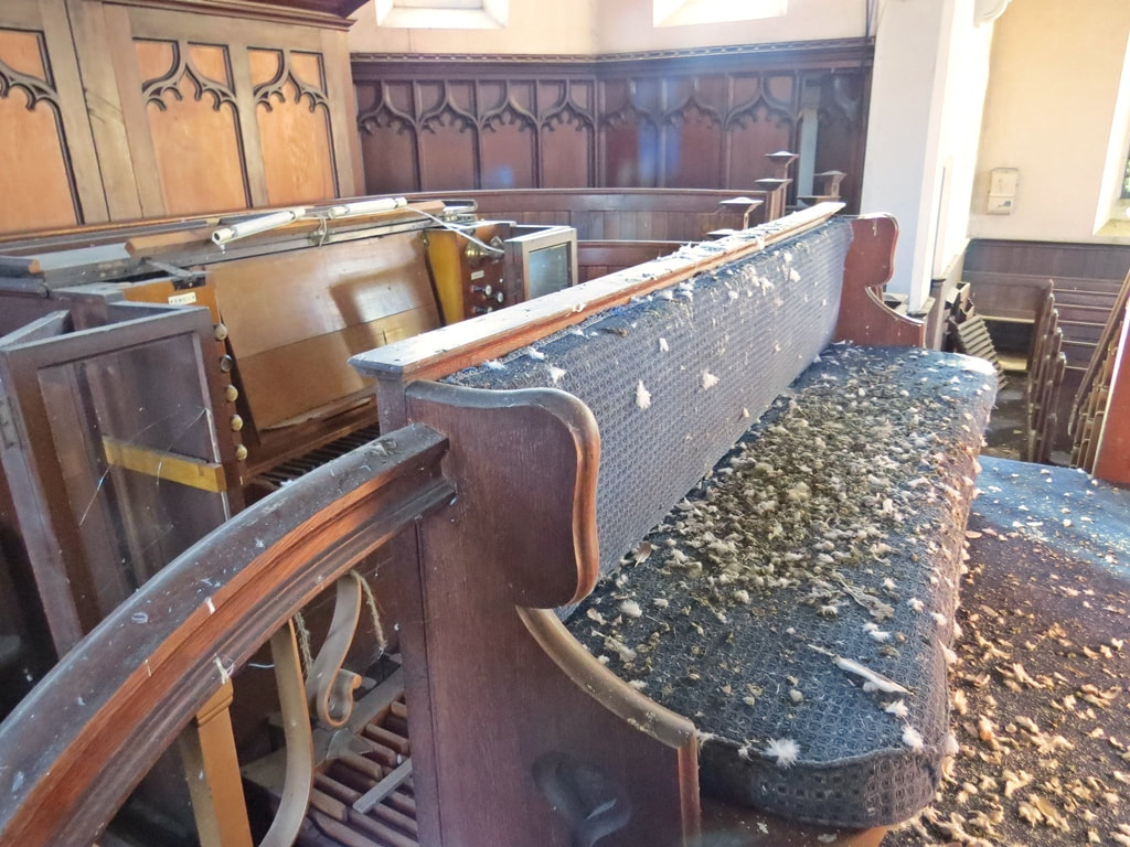 Pigeon mess on the pews and altar of derelict church in South London