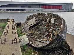 Picture Decaying abandoned rowing boat on Royal Victoria Dock in Newham overlooked by Excel Centre