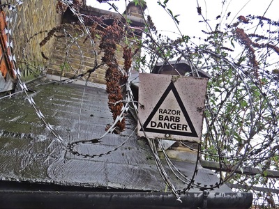 Razor barbed wire danger on abandoned and derelict site in Silvertown, East London