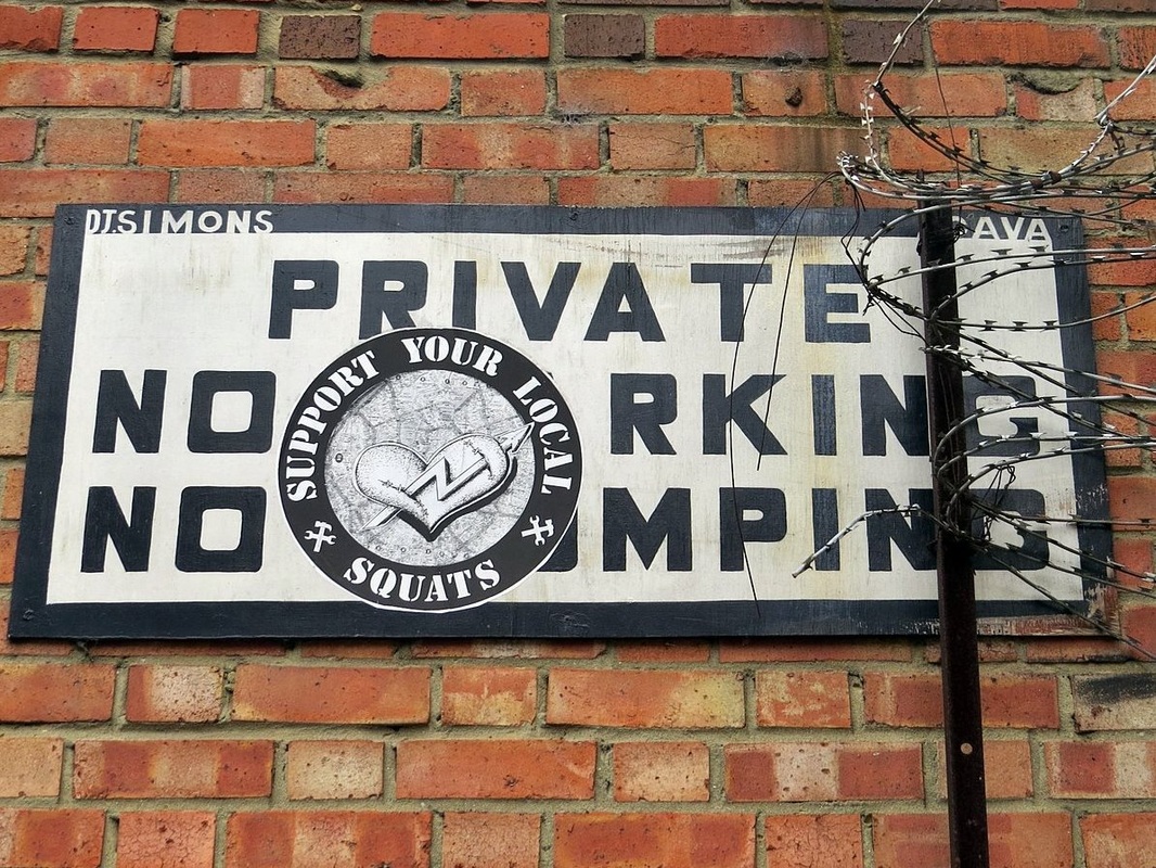 Support your local squats sticker on private no parking sign in Hackney