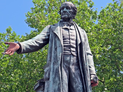 The statue is of the then Liberal Prime Minister William Gladstone erected in 1882 by Theodore Bryant of the nearby Bryant & May match factory.
