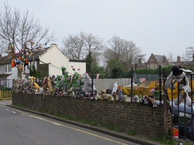 spurned, neglected child's toys dumped and salvaged and attached to a fence