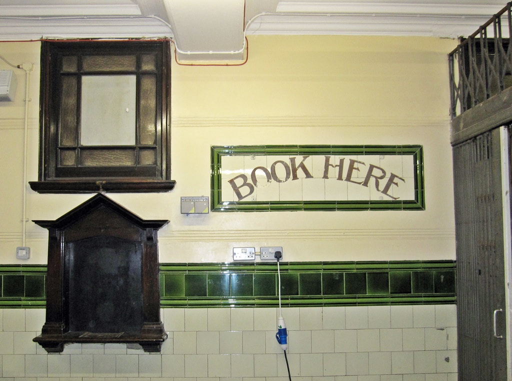 Booking office sign and tiling inside disused Aldwych Underground Station