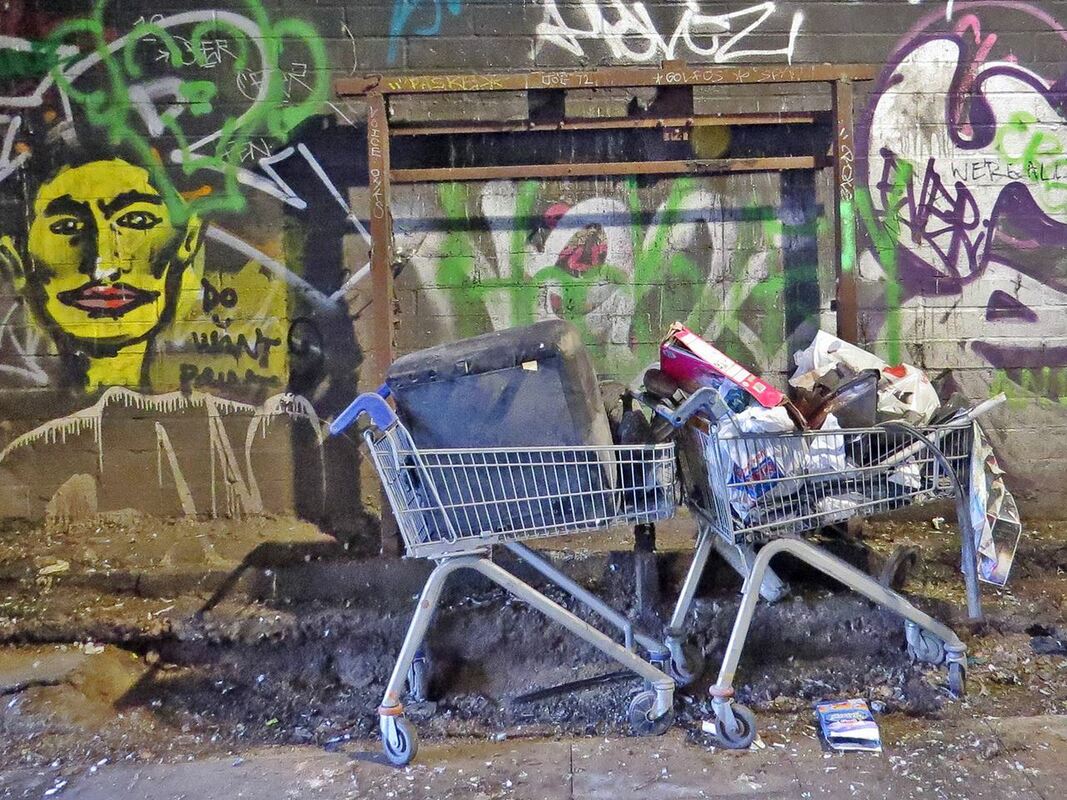 Abandoned shopping trolley and TV under railway arches in Bethnal Green, E1