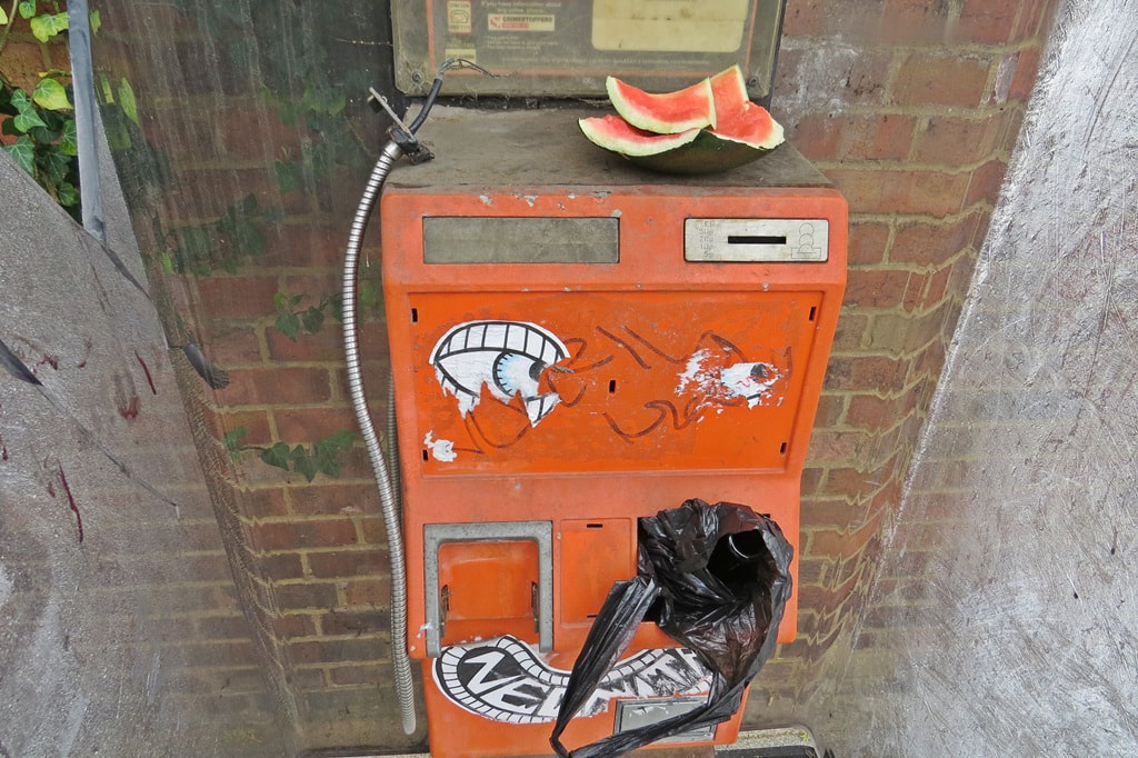 Broken orange payphone in South London