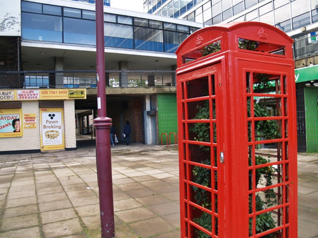 Disused red telephone box in Archway with plants growing in it (popup greenhouse?)