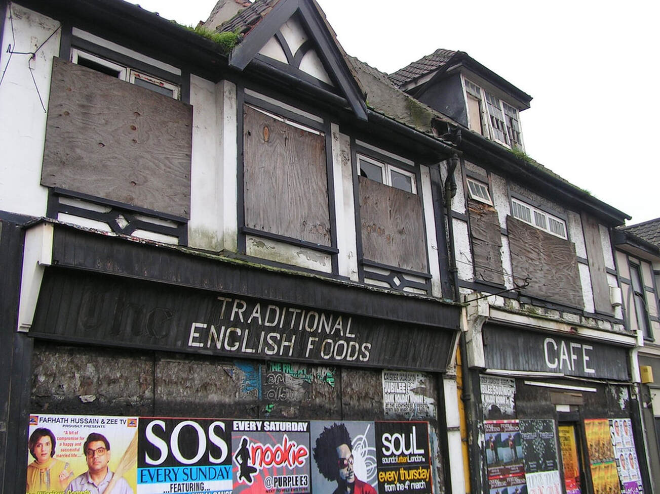 Picture of boarded up with flyposters derelict cafe once offering Traditional English Foods in Dagenham, East London