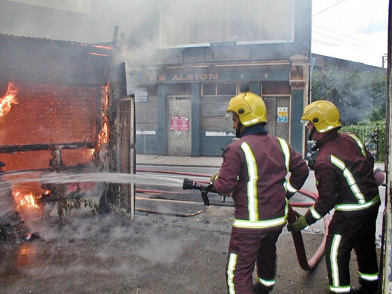 Picture of fireman attending a blaze in derelict East End workshop opposite The Albion closed down pub in Mile End