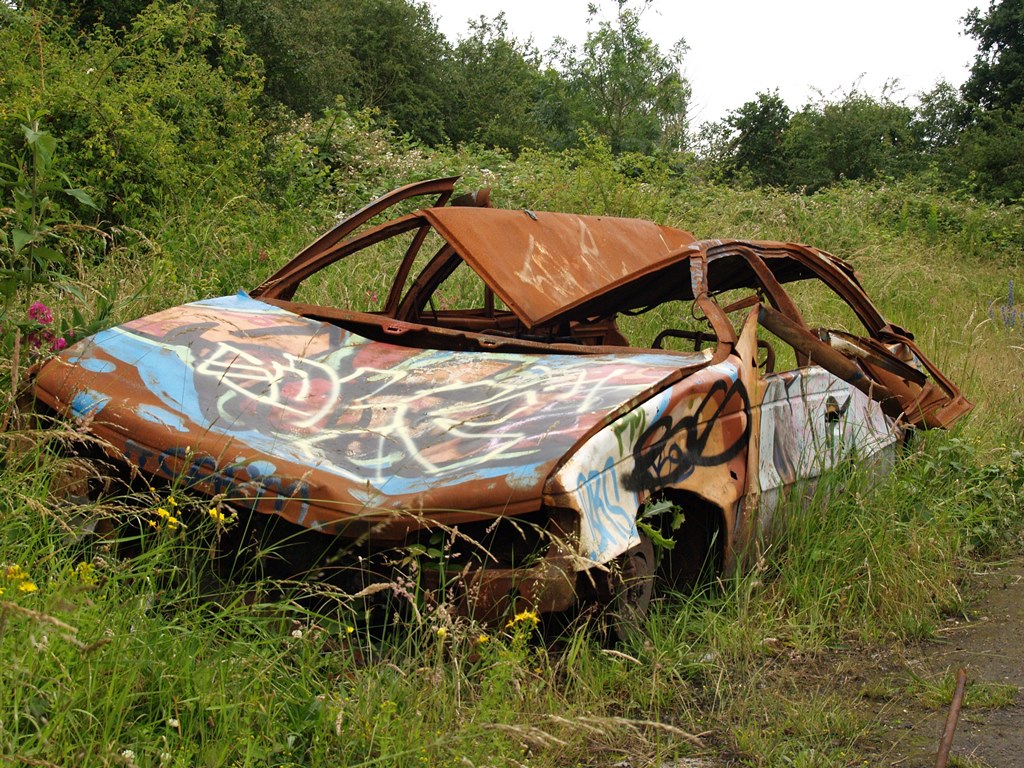 Abandoned burnt out car at ​Feltham Rail Freight Marshalling Yard in SW London
