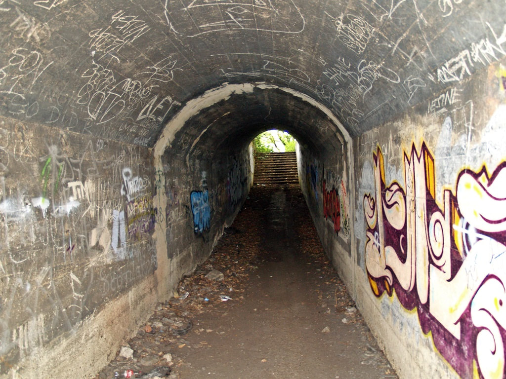 Derelict graffiti covered tunnel in  abandoned Feltham railway yard
