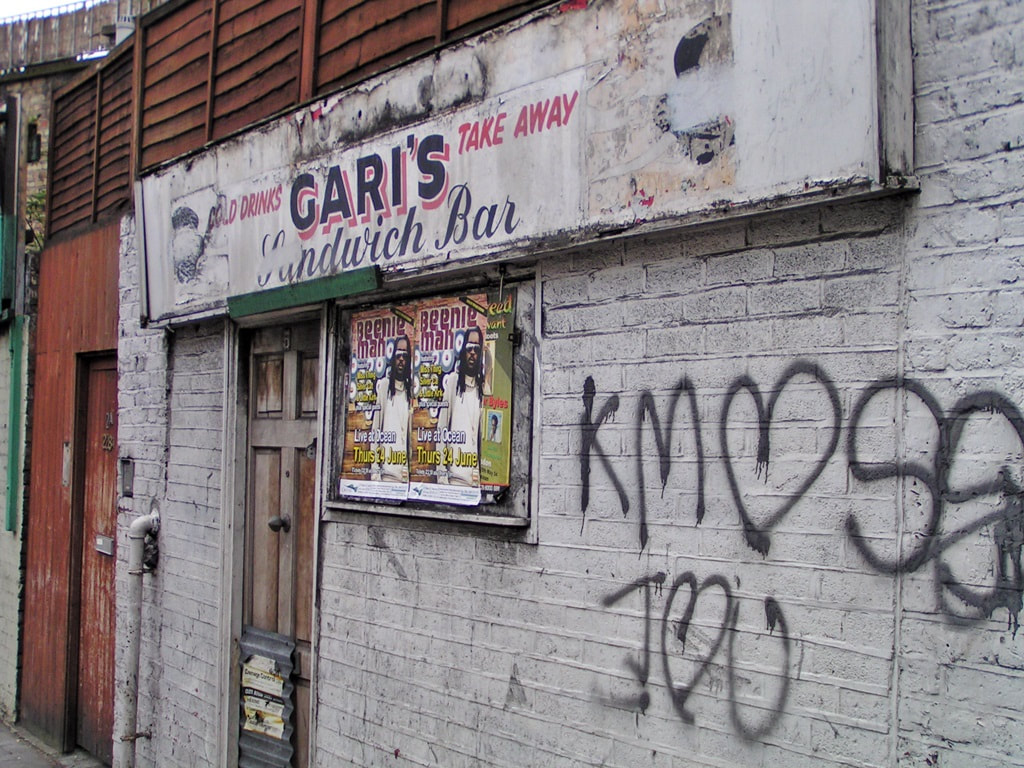 The abandoned Garis Sandwich Bar in Stoke Newington looking dilapidated with fly posters and graffiti