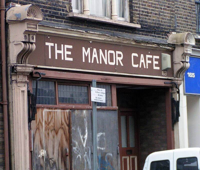 Boarded up closed down brown painted Victorian shopfront of the Manor Cafe at Manor Place, Walworth