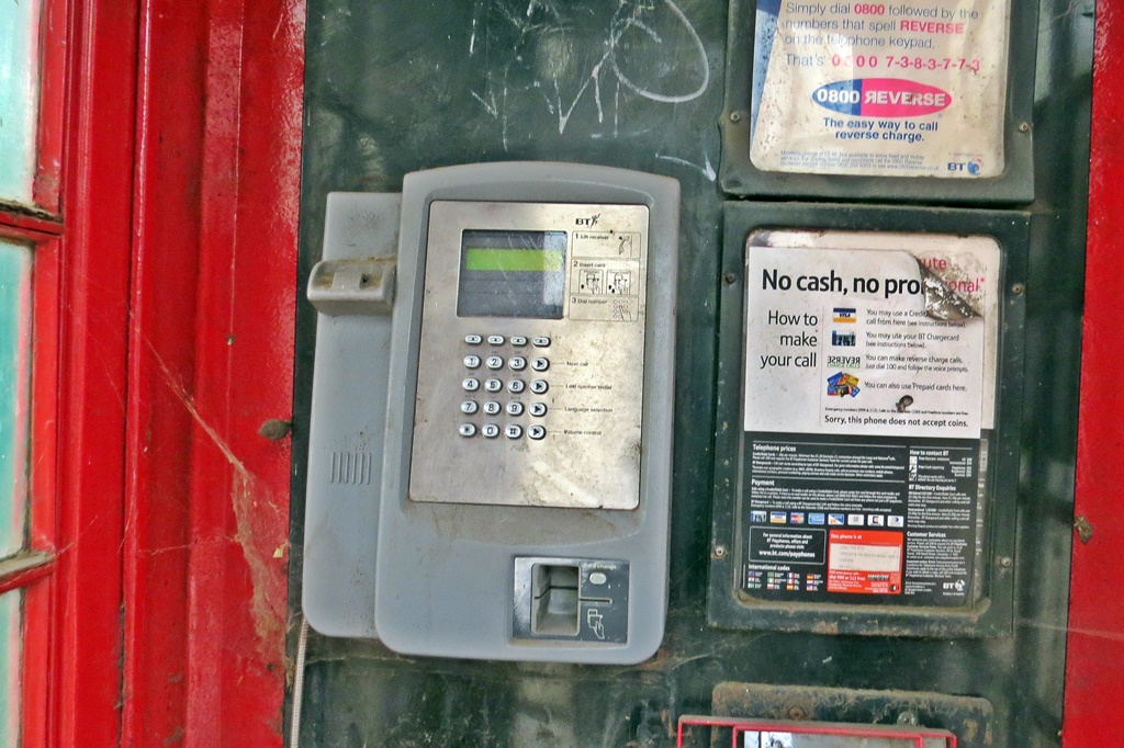 Disused vandalised red public phone box in Elephant & Castle, London