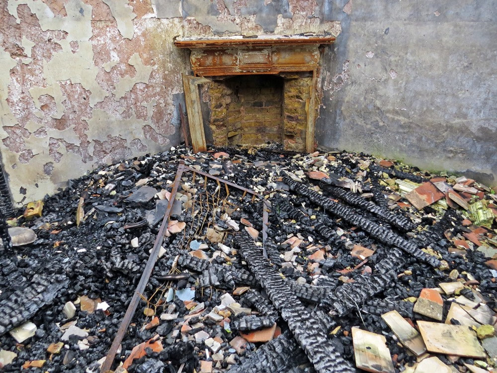 Fire damaged abandoned room with fireplace in decaying London house