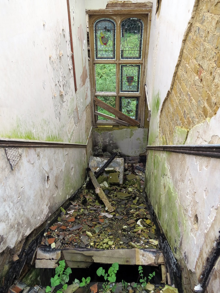 Collapsed stairs and debris  in derelict London mansion