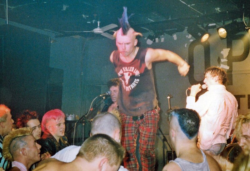 punk rock mohican with tartan trousers stage diving at a gig in Shepherds Bush, West London, W12