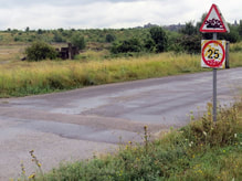 Picture. Disused stretch of road on Swanscombe Marshes  with vandalised streetsigns on Kent's industrial wasteland