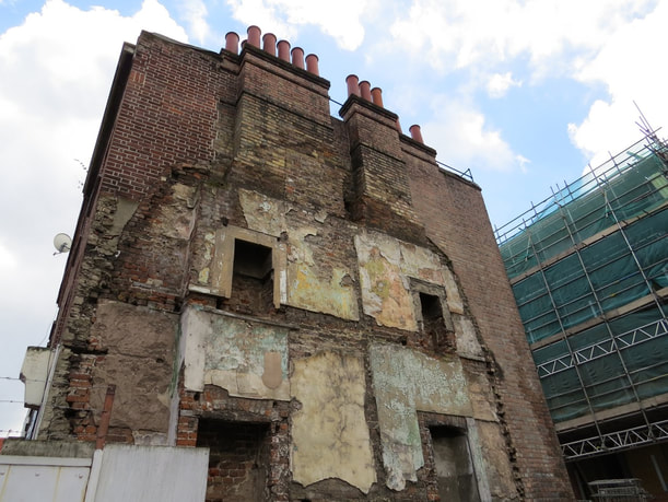 Half demolished building in Whitechapel with old fireplaces exposed