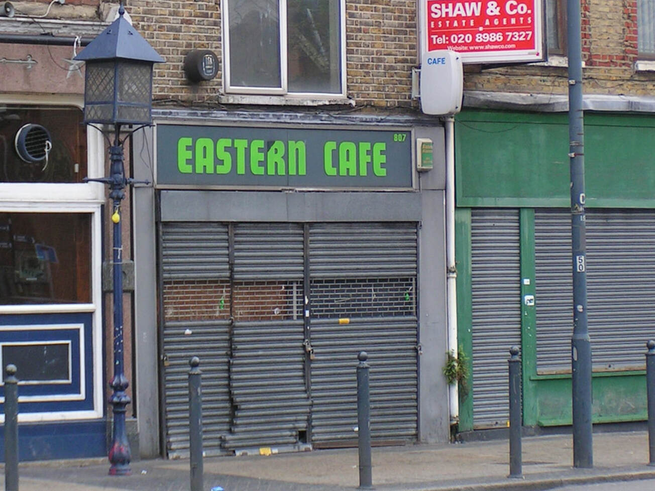 The shuttered exterior of the Eastern Cafe on the Commercial Road next to the old gas lamp of the Star of the East public house