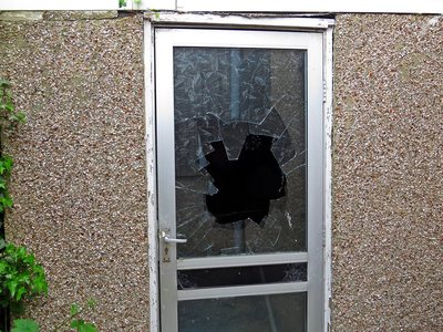 Broken glass of front door of derelict house in Essex
