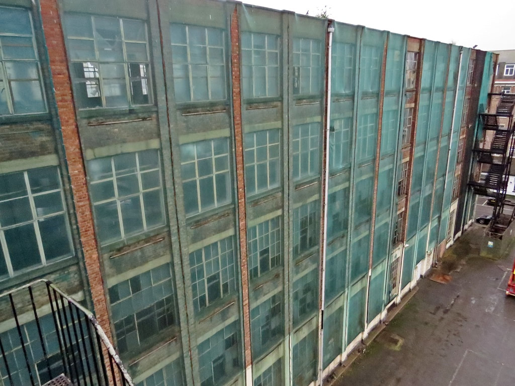 Netting over derelict factory to prevent falling glass and to  prevent pigeons 