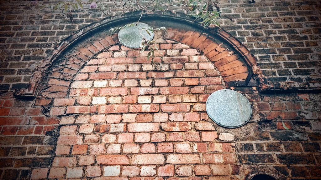 Bricked up windows at discarded Southwark Park station in South London