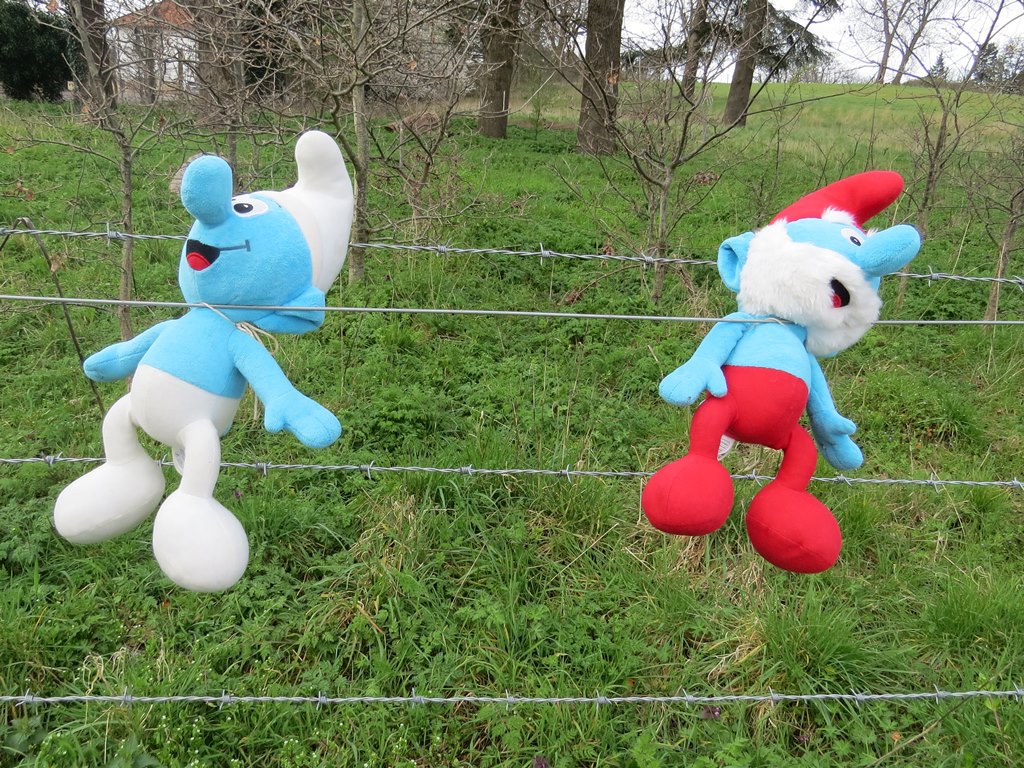 Two Smurf cuddly toys hanging on a fence in North London