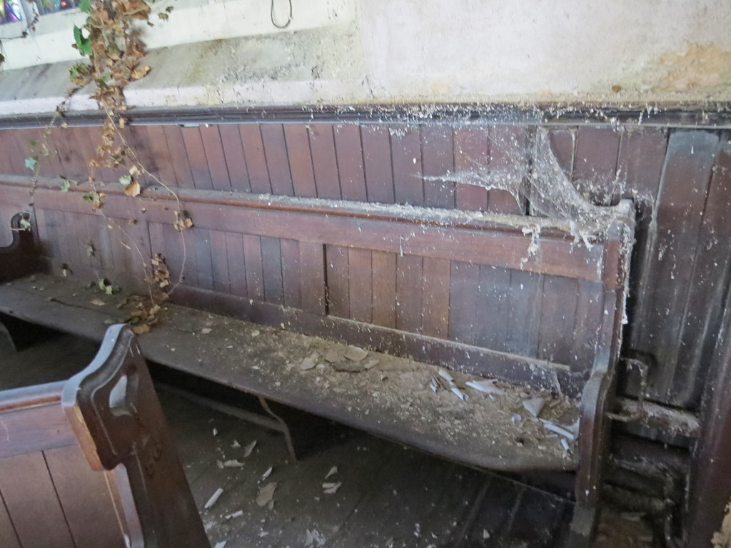 dilapidated pews and cobwebs in derelict South London church
