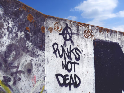 Punks Not Dead and anarchy graffiti along the Thames River path in Essex