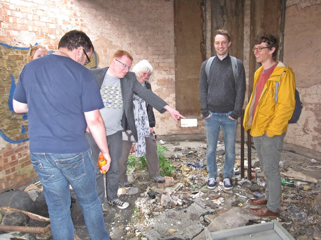 the abandoned interiors of Woolwich Aquatic Centre including Daryl of local blog 853 pointing at a used syringe.